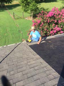 guy on roof nailing shingles