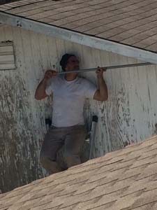 man on ladder working on eaves