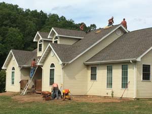 roofing workers on and around house