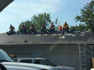 men lined up along roofline
